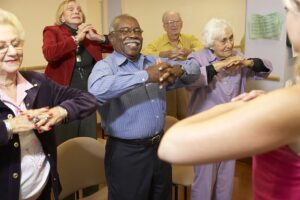 Senior adults in a stretching class watching Instructor